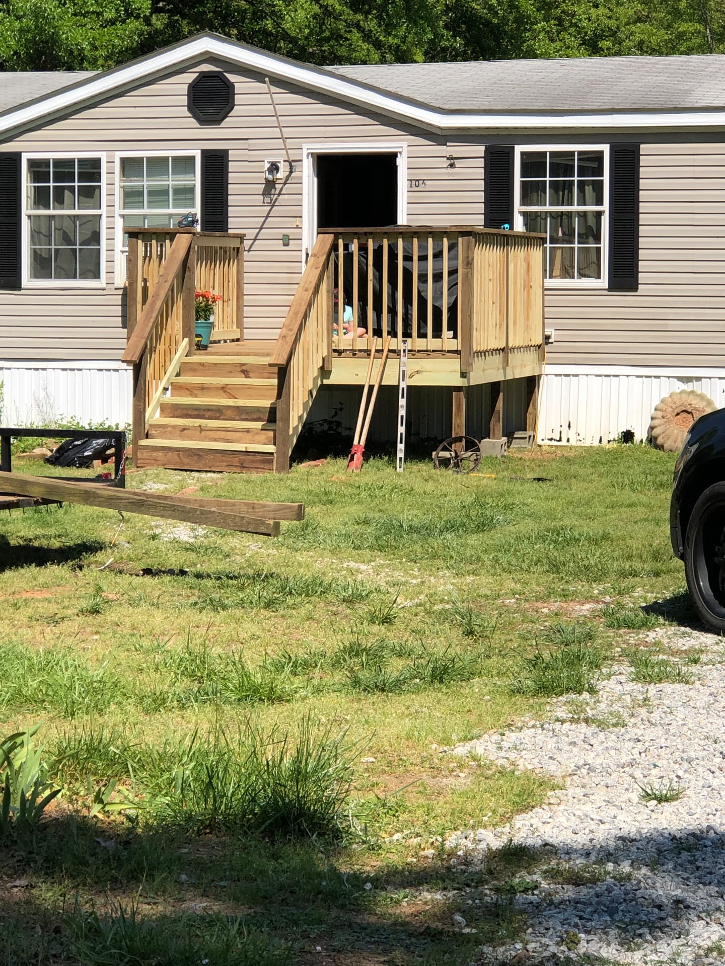 New pressure-treated front deck with railing and stairs on a manufactured home